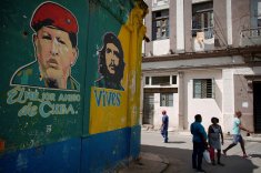 People pass by images depicting Venezuela's late president Chavez and late revolutionary hero "Che" Guevara in downtown Havana